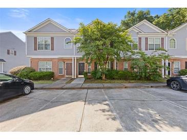 Inviting townhome featuring a brick facade, neutral siding, and well-manicured landscaping at 2566 Walden Lake Dr, Decatur, GA 30035