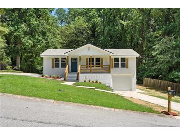Charming white brick home with a welcoming front porch and well-manicured lawn at 3013 Michael Sw Dr, Marietta, GA 30060