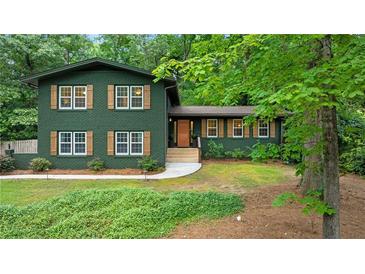 Charming two-story home featuring wood shutters, a well-maintained lawn, and mature shade trees at 3597 Embry Cir, Atlanta, GA 30341