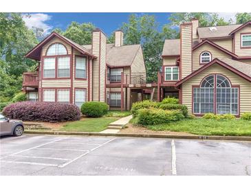 Condominium complex featuring two-story buildings, well-maintained landscaping, and convenient parking spaces at 404 Hawkstone Way, Alpharetta, GA 30022