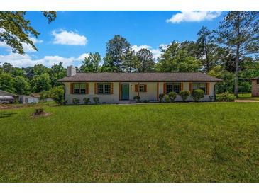 Charming single-story home featuring a manicured lawn, beautiful shutters, and a freshly painted exterior at 2089 Christian Se Cir, Conyers, GA 30013