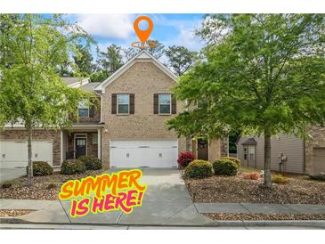 Charming brick townhome with a two-car garage and well-manicured landscaping at 2860 Cooper Brook Dr, Snellville, GA 30078