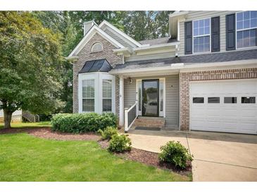 Charming two-story home featuring a manicured lawn, brick accents, and attached two-car garage in a suburban neighborhood at 4000 Mcpherson Drive Dr, Acworth, GA 30101
