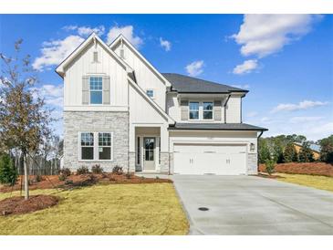 Stunning two-story home featuring a blend of stone and white siding, paired with a well-manicured lawn at 4480 Beechnut Cir, Cumming, GA 30028