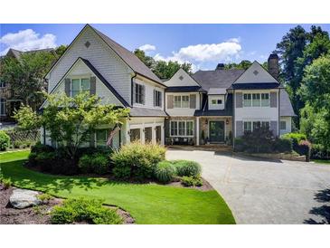Beautiful two-story home featuring a stone chimney, well-manicured lawn and an attached three-car garage at 4559 Paradise Shoals Se Rd, Atlanta, GA 30339
