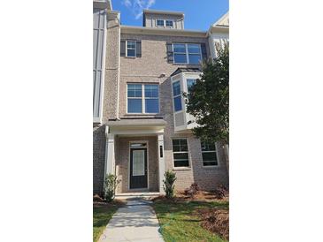 Charming multi-story home featuring a brick facade, multiple windows, and a well-maintained front yard at 547 Fundao Ln # 24, Lawrenceville, GA 30046