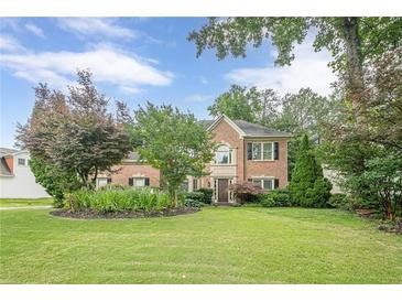 Traditional brick home boasting a manicured lawn and mature landscaping at 10865 Glenhurst Pass, Duluth, GA 30097
