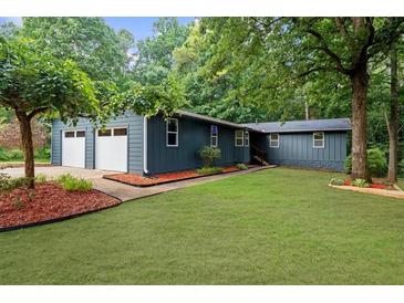 Charming single story home with attached two-car garage and lush green lawn at 30 Roseberry Dr, Stockbridge, GA 30281