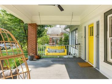 Inviting front porch with a hanging swing, ceiling fan, and charming yellow door at 307 S Mcdonough St, Decatur, GA 30030