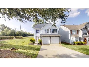 Charming two-story home featuring a two-car garage, neutral siding, and well-maintained landscaping at 1001 Balsam Wood Trl, Villa Rica, GA 30180