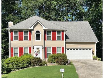 Charming two-story home with red shutters, a well-manicured lawn, and an attached two-car garage at 1019 Wolf Springs Ct, Lawrenceville, GA 30043