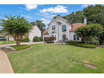 Charming two-story home featuring a manicured lawn and well-maintained landscaping at 1430 Grovehurst Dr, Marietta, GA 30062