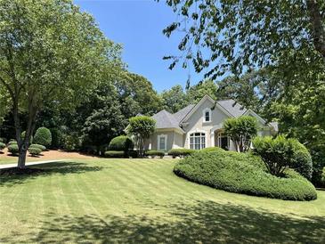 Charming home featuring manicured lawn and lush, mature landscaping, offering great curb appeal at 605 Meadows Creek Dr, Johns Creek, GA 30005