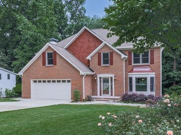 Traditional two-story brick home with a well-manicured lawn, mature trees and an attached two-car garage at 4271 Edgewater Drive Northwest Nw Dr, Kennesaw, GA 30144