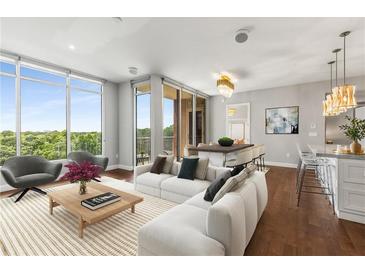 Bright living room with large windows, modern furniture, and access to a balcony showcasing the beautiful outdoor view at 1820 Peachtree Nw St # 804, Atlanta, GA 30309