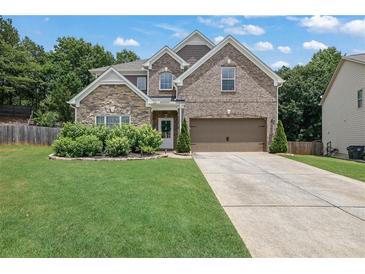 Charming two-story home featuring a manicured lawn, brick and stone accents, and a two-car garage at 280 Woods Creek Drive, Suwanee, GA 30024
