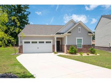 Charming single-story home with a two-car garage and a well-manicured lawn at 7301 Cranleigh St, Covington, GA 30014