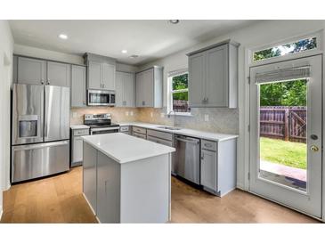 Modern kitchen featuring stainless steel appliances, a center island, and light gray cabinets at 5312 Brooklands Dr, Lithonia, GA 30058