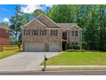 Charming brick two-story home featuring a manicured lawn and a two-car garage at 2015 Chapel Estates Lane Southeast Ln, Dacula, GA 30019