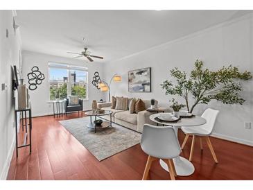 Bright living room features hardwood floors, natural light, a ceiling fan, and modern decor at 390 17Th Nw St # 4031, Atlanta, GA 30363