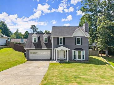 Charming two-story home featuring a two-car garage, manicured lawn, and classic architectural details at 625 Hickory Nobb, Sugar Hill, GA 30518