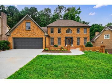 Charming brick home with a well-manicured lawn and a two-car garage at 5826 Andover Way, Tucker, GA 30084
