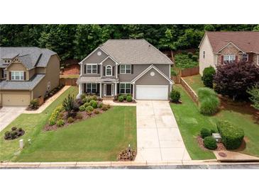 Charming two-story home with a well-manicured lawn and mature trees offering curb appeal at 1810 Stardust Trl, Cumming, GA 30040