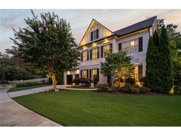 Well-manicured front yard, black shuttered windows and garage on a two-story home at dusk at 1059 Rockford Township Sw Dr, Marietta, GA 30064