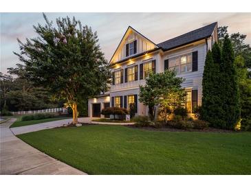 Charming two-story home featuring a lush green lawn, mature landscaping, and classic black shutters at 1059 Rockford Township Sw Dr, Marietta, GA 30064
