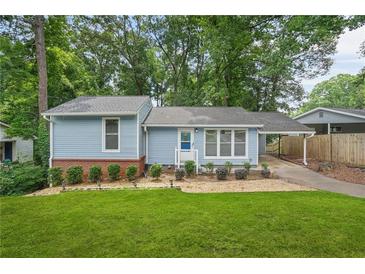 Charming blue home featuring a well-manicured lawn and a cozy covered parking area at 4981 Crowe Se Dr, Smyrna, GA 30082