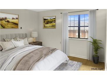 A bedroom featuring a comfortable bed, artwork, and a window with natural light at 475 Mount Vernon Ne Hwy # C230, Sandy Springs, GA 30328