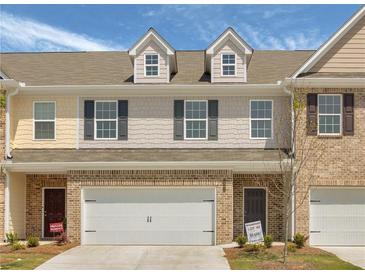 Charming townhome featuring a two-car garage and classic brick and siding details at 2841 Fareed, Douglasville, GA 30135