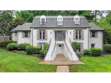 Charming two-story home with symmetrical design, landscaped yard, and double staircase leading to the front entrance at 5105 Vernon Oaks Dr, Dunwoody, GA 30338
