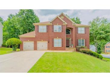 Charming two-story brick home with a well-manicured lawn and a three car garage at 10950 Glenhurst, Duluth, GA 30097
