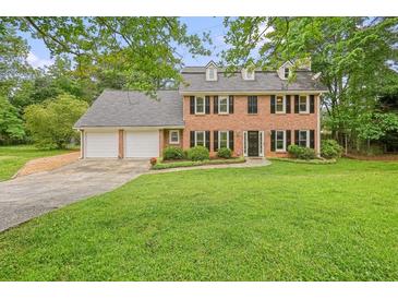 Traditional brick home with a lush green lawn, attached two-car garage and well-maintained landscaping at 2801 Holly Oaks Dr, Marietta, GA 30062