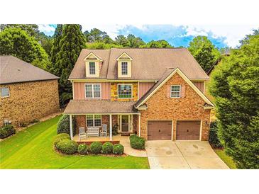 Charming home featuring a brick and stone facade, complemented by a well-manicured lawn and a two-car garage at 4978 Arborview Pkwy, Acworth, GA 30101