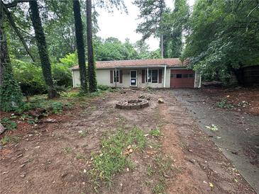 Single story home with lawn needing love and prominent fire pit feature at 2612 Ramblewood Ct, Acworth, GA 30102