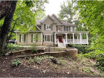 Beautiful two-story home with a welcoming front porch and well-maintained landscaping and a red front door at 1170 Spring Oak Way, Cumming, GA 30041
