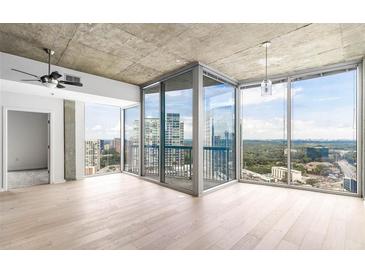 Bright living room featuring hardwood floors, ceiling fan, and floor-to-ceiling windows with a city view at 3324 Peachtree Ne Rd # 2518, Atlanta, GA 30326