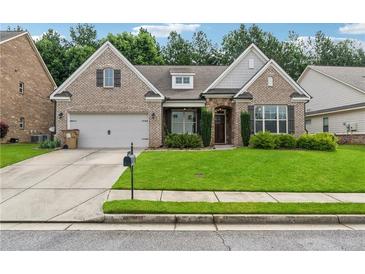 Charming brick home with a well-manicured lawn and a two-car garage at 430 La Perla Dr, Sugar Hill, GA 30518