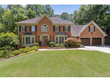 Beautiful two-story brick home with mature trees, manicured lawn and three-car garage at 1835 Redbourne Dr, Atlanta, GA 30350
