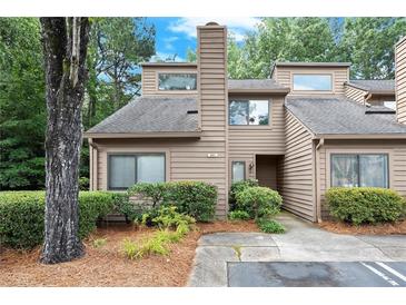 Charming townhouse exterior with landscaped front and classic architectural details and lush surroundings at 301 Parkaire Xing, Marietta, GA 30068
