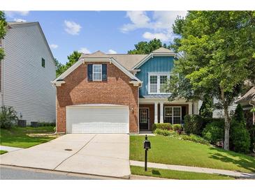 Charming two-story home featuring a brick facade, manicured lawn, and attached two car garage at 606 Lorimore Pass, Canton, GA 30115
