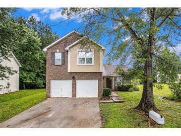 Charming two-story home featuring a brick and siding exterior, attached two-car garage, and well-maintained front lawn at 6177 Idlewood Cir, Lithonia, GA 30038