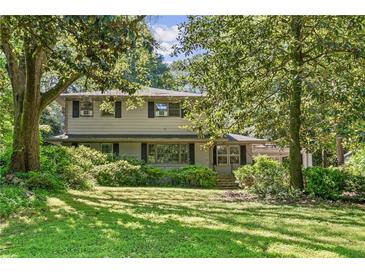 Traditional home with large trees, lush green grass, and manicured shrubs in a quiet neighborhood at 2839 Orion Dr, Decatur, GA 30033