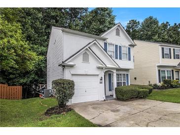 Charming two-story home with white stucco, attached garage, blue shutters, and manicured landscaping at 2894 Regent Walk Dr, Duluth, GA 30096