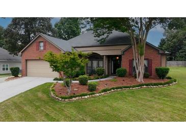 Charming brick home with manicured front yard and mature trees at 3262 Beech Hollow Ct, Loganville, GA 30052