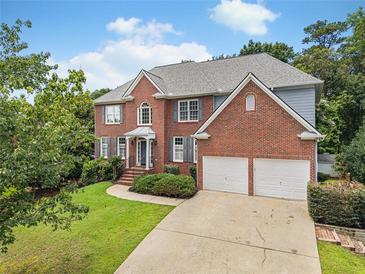 Beautiful two-story brick home with a two-car garage, manicured lawn, and mature trees at 358 Woodbrook Crst, Canton, GA 30114