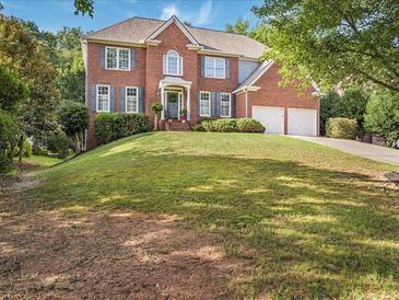 Two-story brick home featuring a manicured lawn and a two-car garage at 358 Woodbrook Crst, Canton, GA 30114