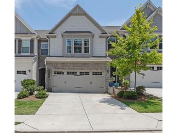 Charming townhouse with a two-car garage, neat landscaping, and an inviting facade at 1969 Lanier Harbor Pt, Buford, GA 30518